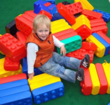 Enfant jouant au Légo géant